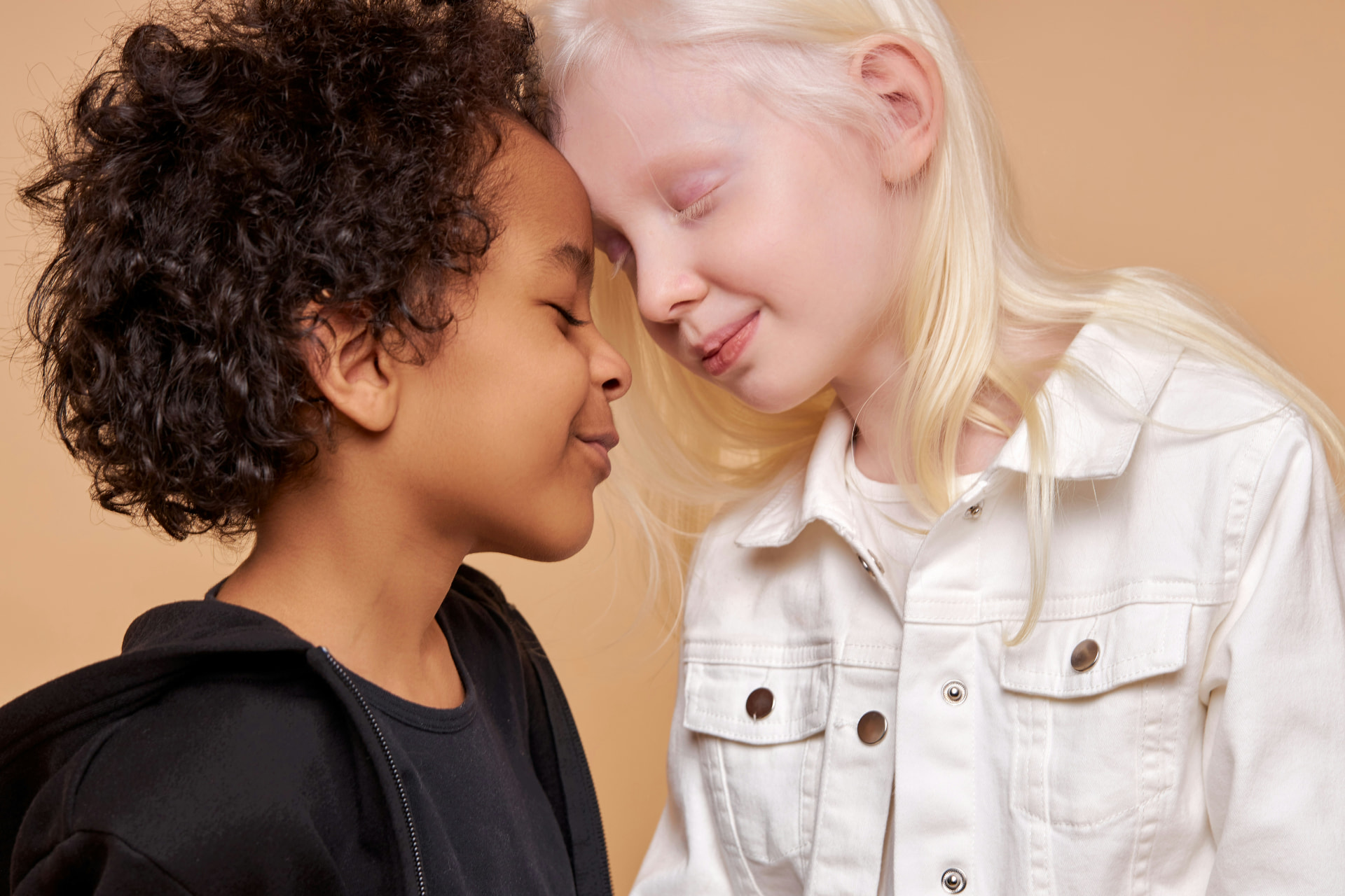 Two students of different backgrounds resting their heads together