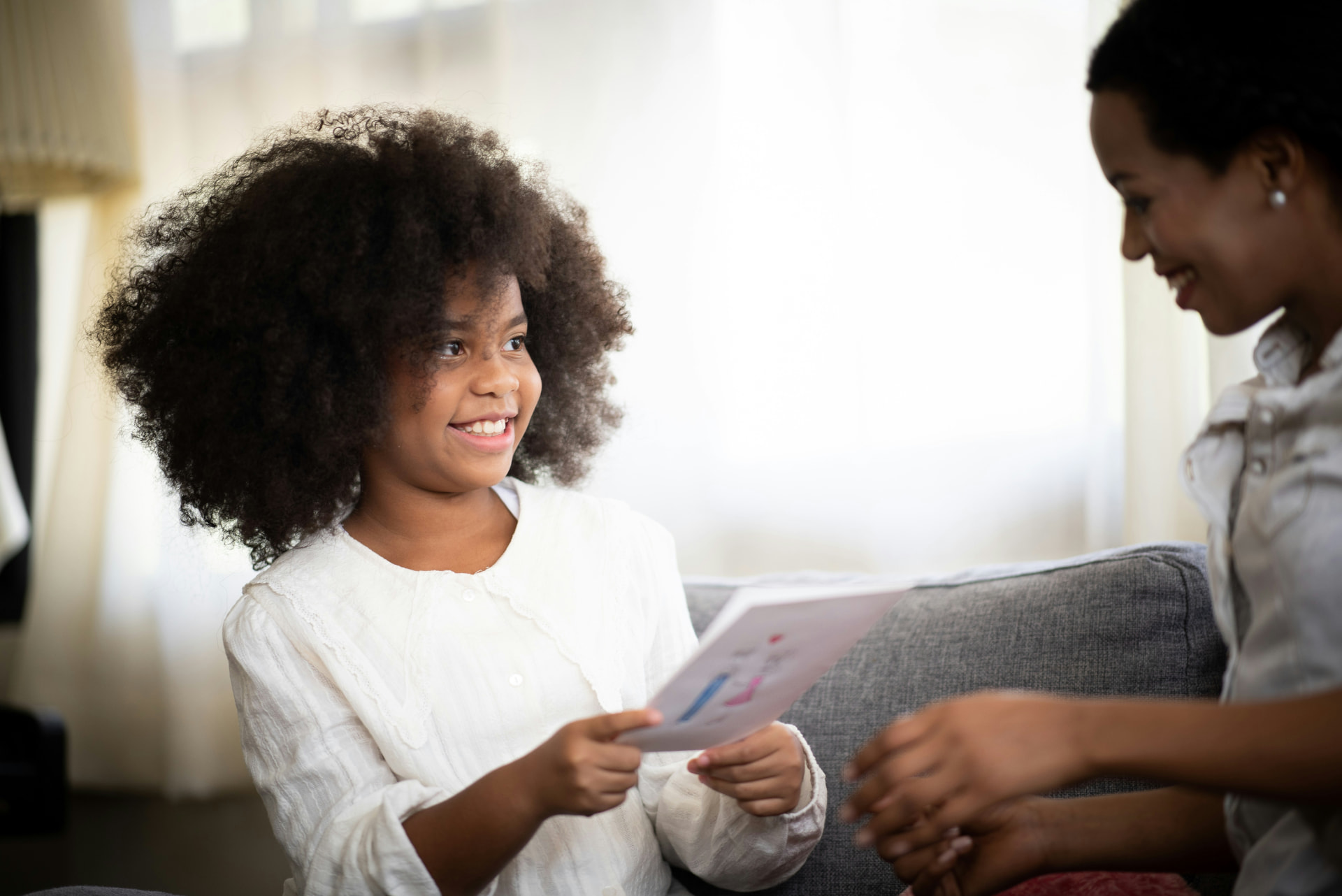A smiling student and an educator reviewing a worksheet together